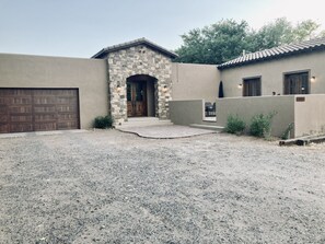 A house with a stone entrance, a garage, and a patio area. - Custom built family home, close to balloon fiesta park  (Albuquerque)