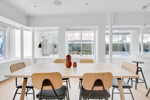 Enjoy meals in this dining area with a long table and six chairs, offering views of the outside.