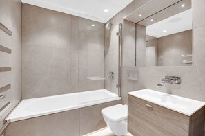 Enjoy a refreshing shower or soak in the separate bathtub in this spacious bathroom.