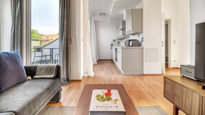 A modern apartment with a living room, a dining area, and a kitchen.