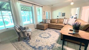A living room with a sectional sofa, a chair, a coffee table, and a rug.