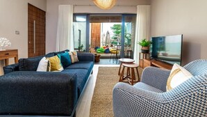 A modern living room with a sofa, armchair, and a television.