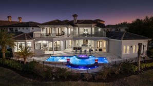 A large, two-story house with a swimming pool and a hot tub. - Legends Palmer: Private Pool, Game Room, Theater, Gym, Free Water Park, Near Disney (Kissimmee)