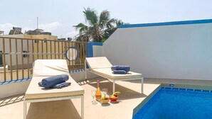 A rooftop pool area with lounge chairs, a table with drinks, and a clear blue pool. - Sunny pool and terrace - Merill nb1, Mellieha, Malta (Mellieha)