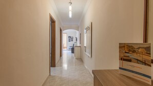A hallway with a wooden reception desk, framed pictures on the wall, and a sign for Happy Rentals. - Sunny pool and terrace - Merill nb1, Mellieha, Malta (Mellieha)