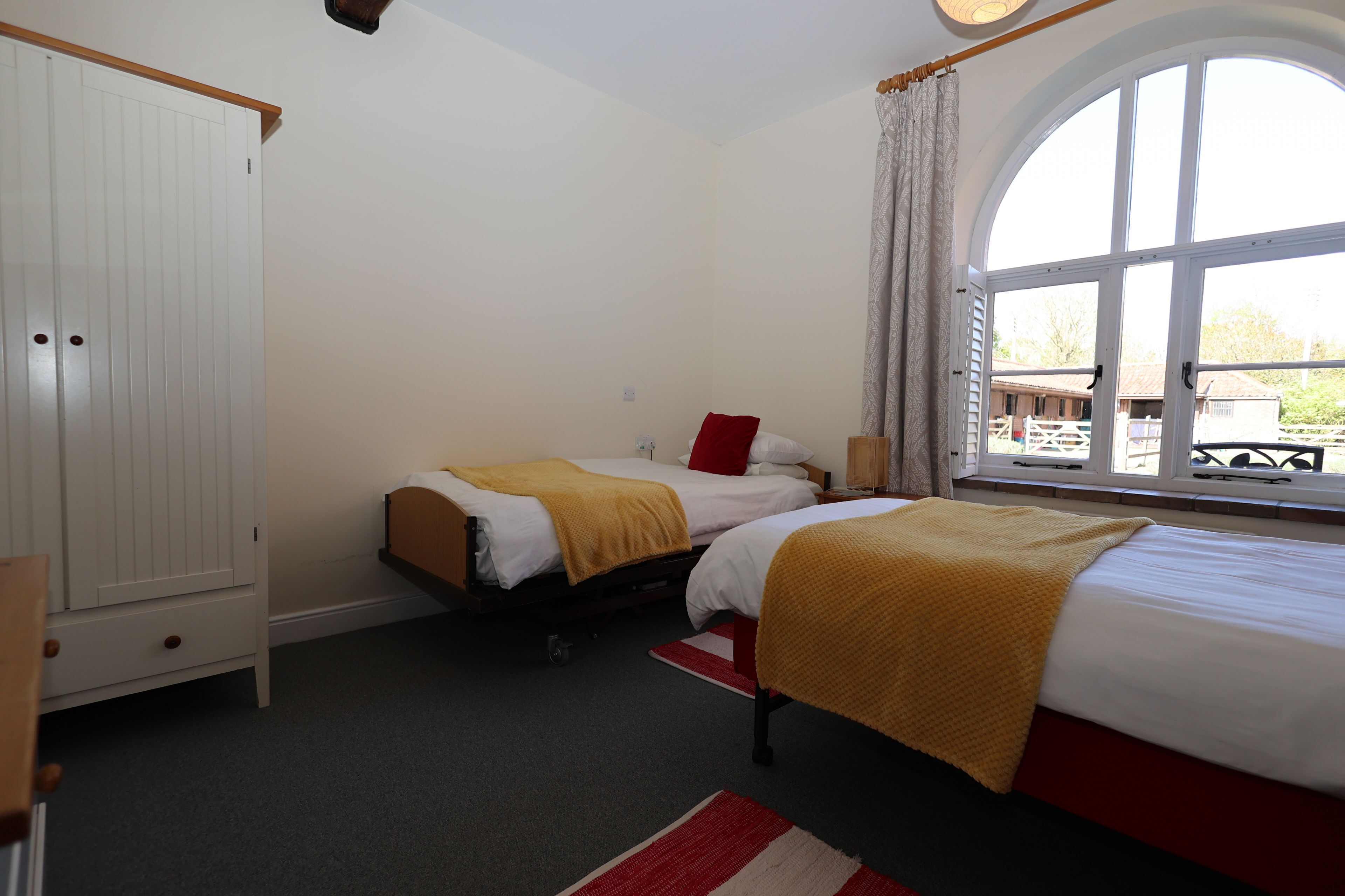 Un dormitorio con dos camas, un armario y una ventana con vistas al exterior.