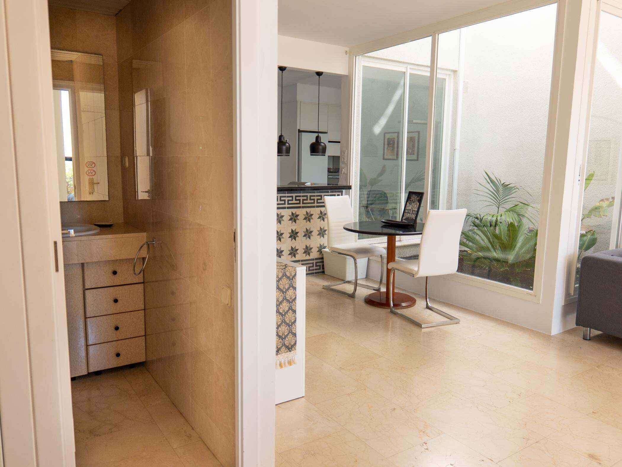 A modern kitchen with a dining area, a large window, and a view of the outside.