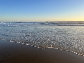 A beach with waves gently lapping onto the shore. - Villa Serena Condo (Rosarito)