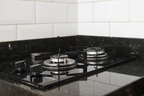 A kitchen with a black countertop and white tiled backsplash.