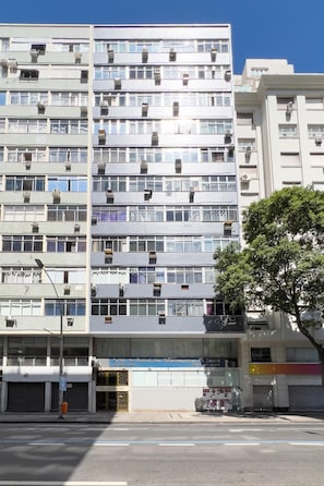 A multi-story building with numerous balconies and air conditioning units.