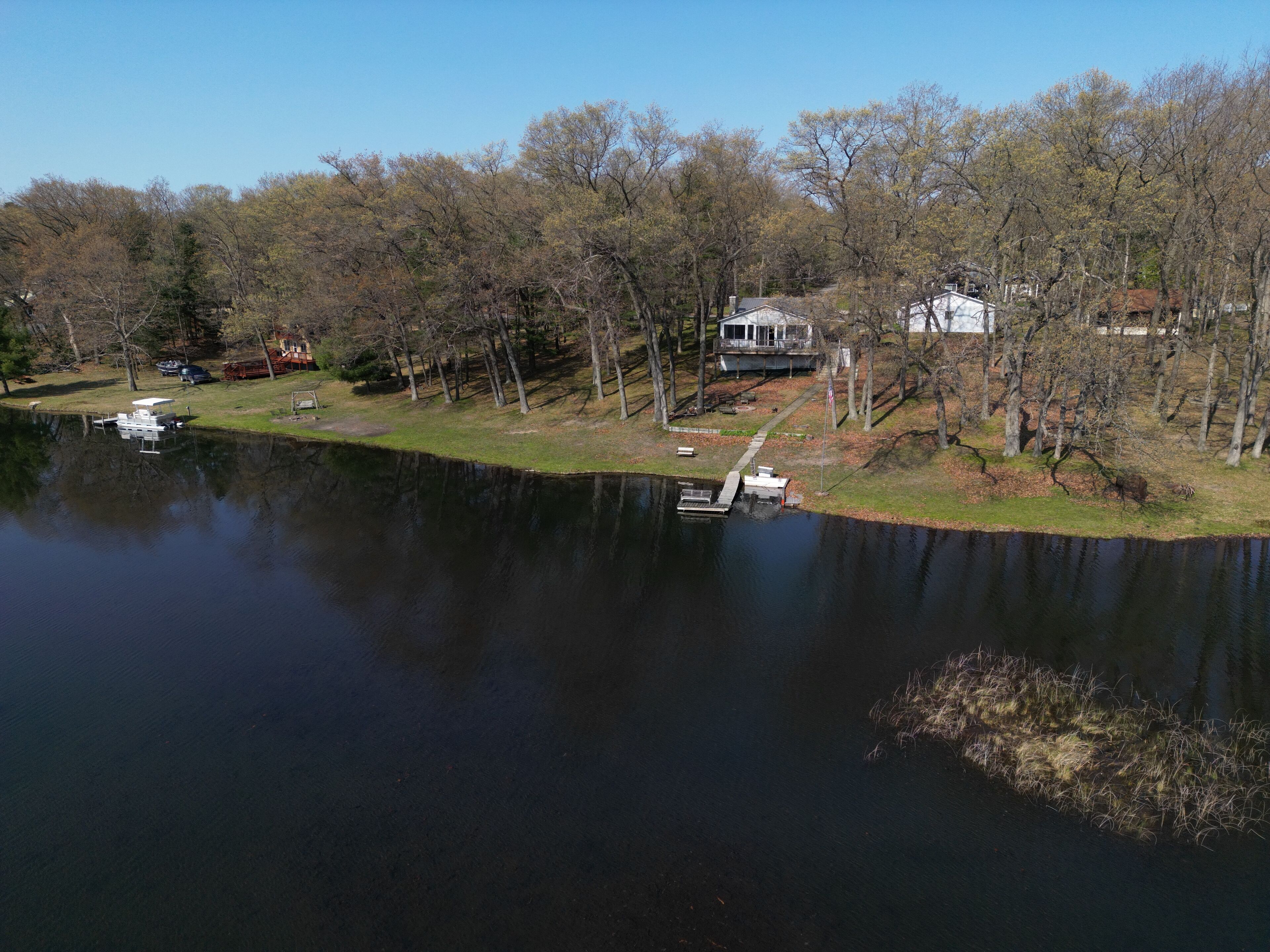 A lakeside property with a dock, a house, and a boat.