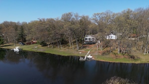 Una propiedad frente al lago con muelle, casa y un bote.