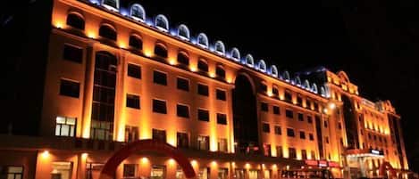 A large, multi-story hotel with a prominent arched entrance and multiple balconies.