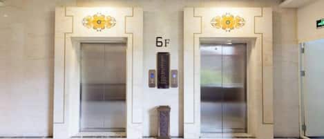 An elevator area with two elevators, each marked with a number.