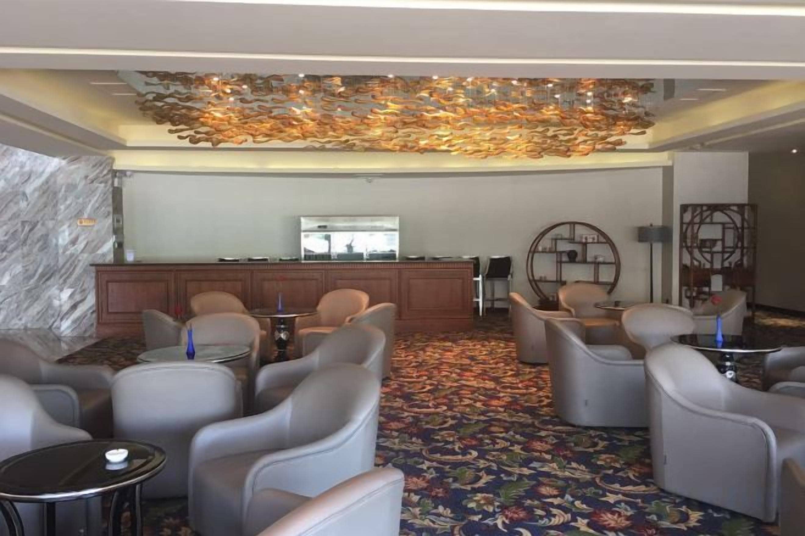 A lobby with seating, a reception desk, and a decorative ceiling.