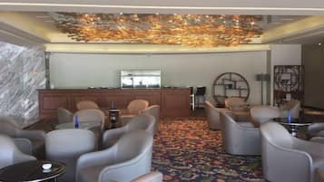A lobby with seating, a reception desk, and a decorative ceiling.