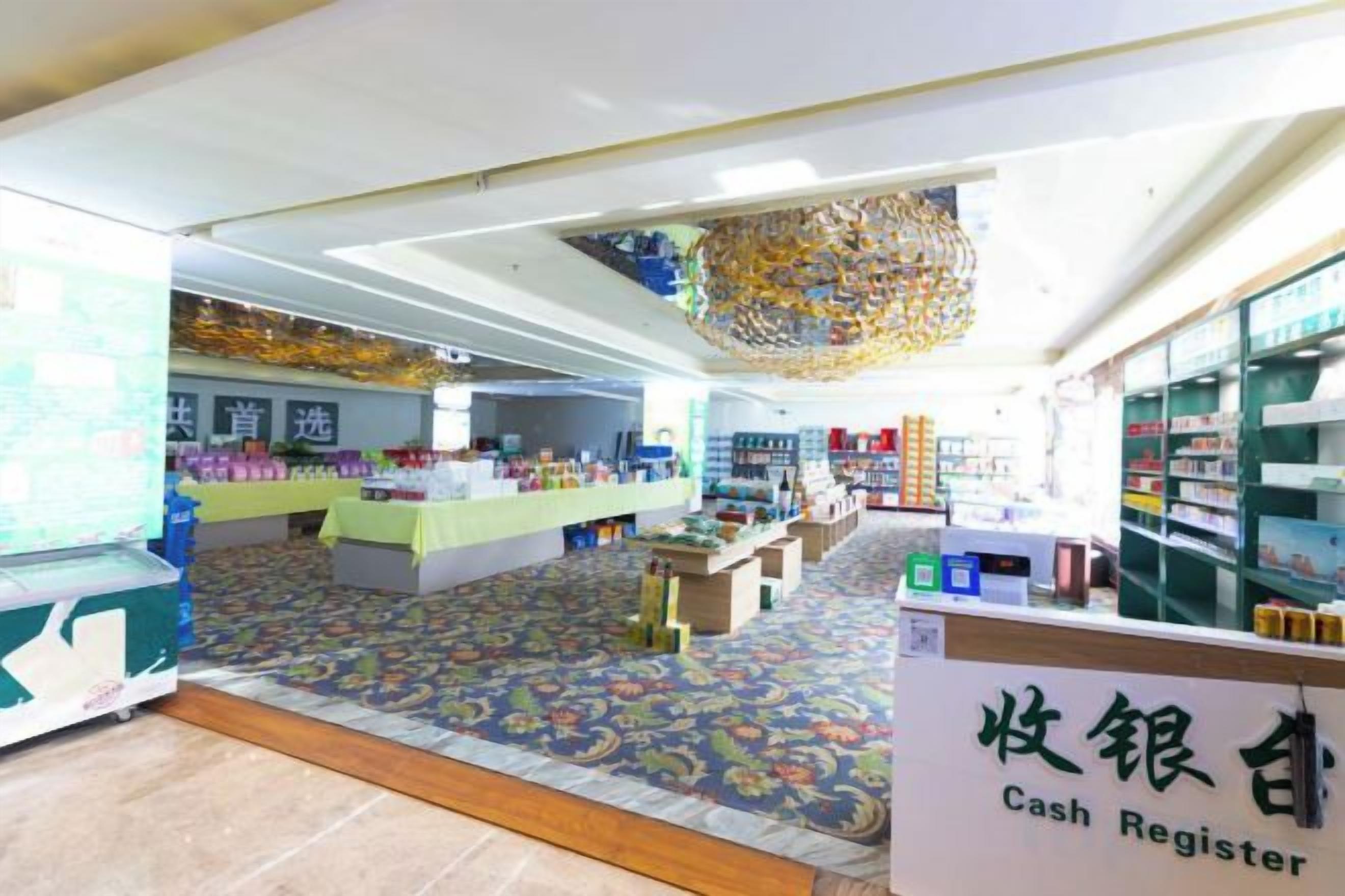 A spacious indoor area with a cash register counter, various shelves stocked with products, and a patterned floor.
