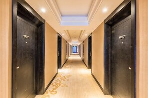 Pasillo de hotel con puertas que indican 'HOTEL' y piso alfombrado.