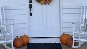 A white house with the number 254 above the door, a wreath with autumn leaves, two rocking chairs, and two pumpkins on the porch. - 1875 FARMHOUSE renovated with a spectacular view! SUMMER SPECIALS! (Luray)