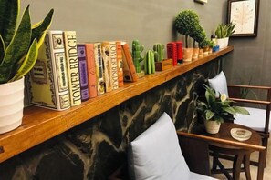 A shelf with books and potted plants. - Bei'an Theme Hotel (Deqing)