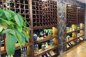 A wine cellar with wooden shelves and a stone wall. - Bei'an Theme Hotel (Deqing)