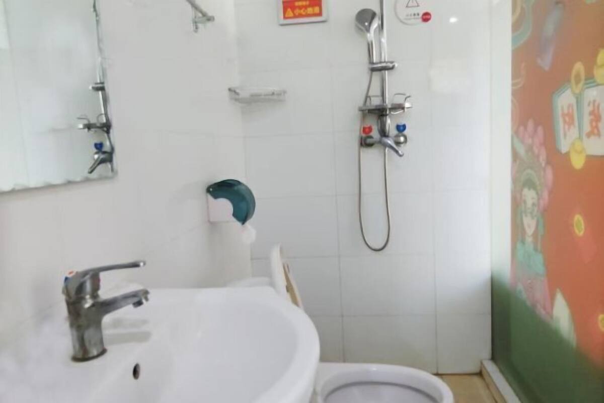 Une salle de bain avec un lavabo, des toilettes et une douche.