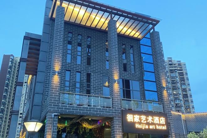 A multi-story building with a sign for Huijie Art Hotel.