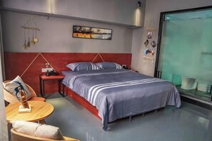 Un dormitorio moderno con una cama grande, una mesita de noche y una pequeña mesa redonda con sillas.