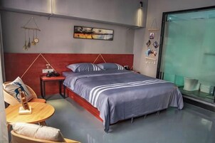 Un dormitorio moderno con una cama grande, una mesita de noche y una pequeña mesa redonda con sillas.
