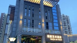 A modern hotel with a prominent art gallery on the ground floor, large windows, and a clear sky. - Huaijia Art Hotel (Qinzhou)