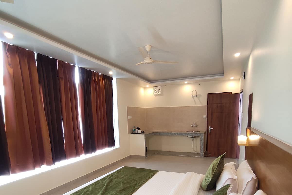 A hotel room with a large bed, a bathroom, and a view of the city.
