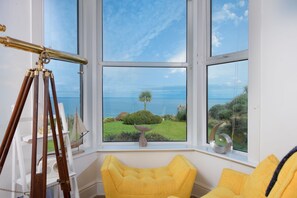 Relax in a serene coastal retreat with a bay window offering breathtaking views of the surrounding landscape.
