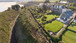 An aerial view of a residential area with houses, a railway track, and a river.