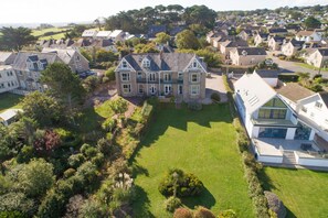 Stunning two-story house with a traditional architectural style, set amidst lush lawns and mature trees in a cohesive neighborhood.