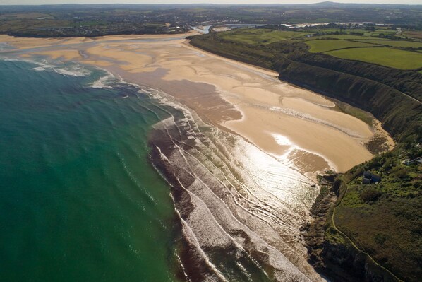 Overlooking a wide sandy beach and a rocky shoreline, this coastal area offers breathtaking views.