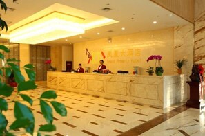 A hotel reception area with a marble reception desk, a large wall-mounted sign, and potted plants. - Phoenix Grand Hotel (Xianyang Yangling) (Xianyang)