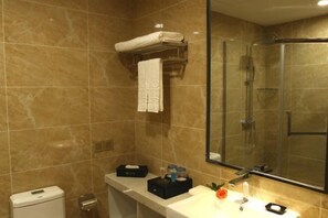 A bathroom with a glass-enclosed shower, a white sink with a mirror above it, and a towel rack with a folded towel. - Phoenix Grand Hotel (Xianyang Yangling) (Xianyang)
