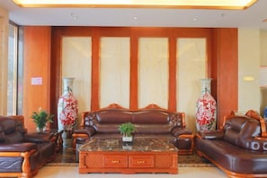 A lobby with leather sofas, a coffee table, and two large vases. - Jingxin Hotel (Yuxi)