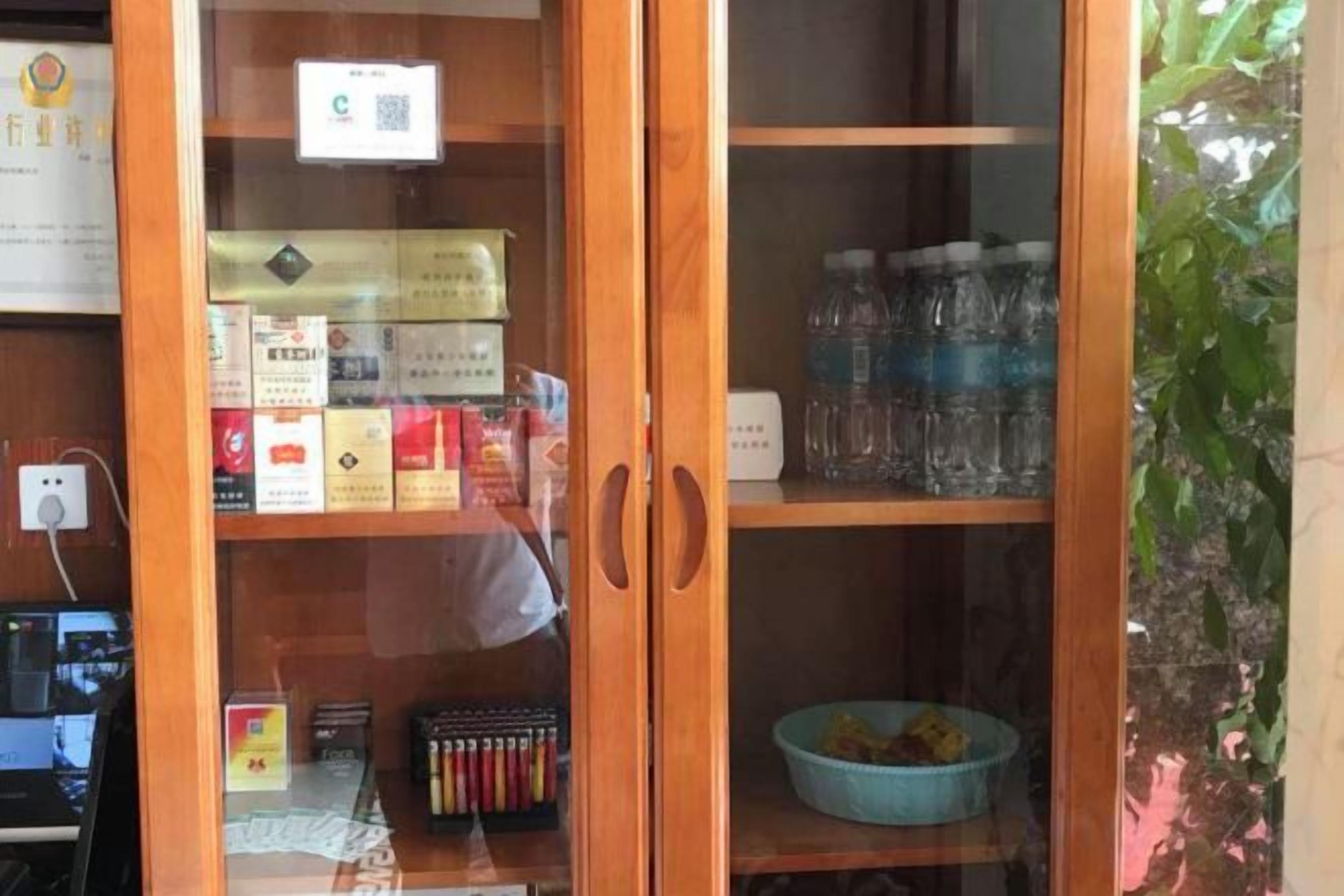 Un mueble de madera con puertas de cristal que contiene varios objetos.