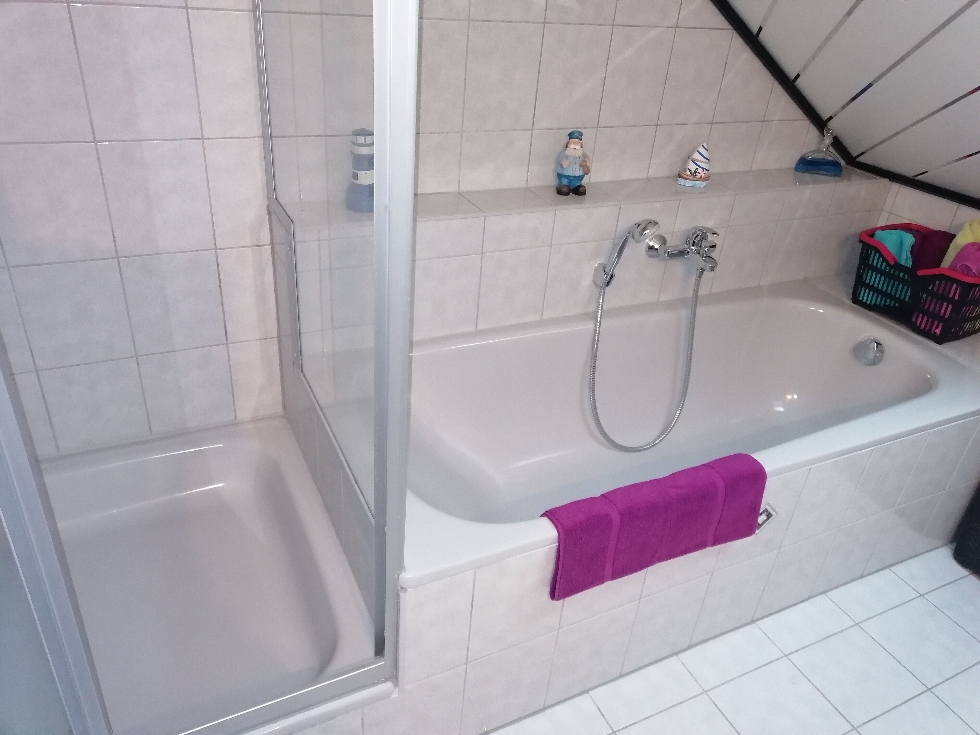 Un baño con ducha, bañera y un estante con artículos de aseo.