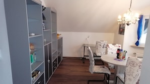 A dining area with a round table, chairs, and a bookshelf. - Vacation apartment with great views and hiking trails right outside the door (Burladingen)