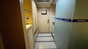 Un corridoio stretto con una porta in legno alla fine, con la scritta 'KERMA'.