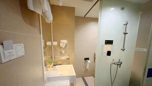 Un bagno moderno con cabina doccia in vetro, un lavandino bianco e uno specchio.