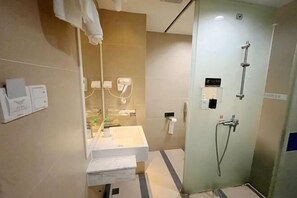 A modern bathroom with a glass shower enclosure, a white sink, and a mirror. - Ke'erma Business Hotel (Zhongshan)