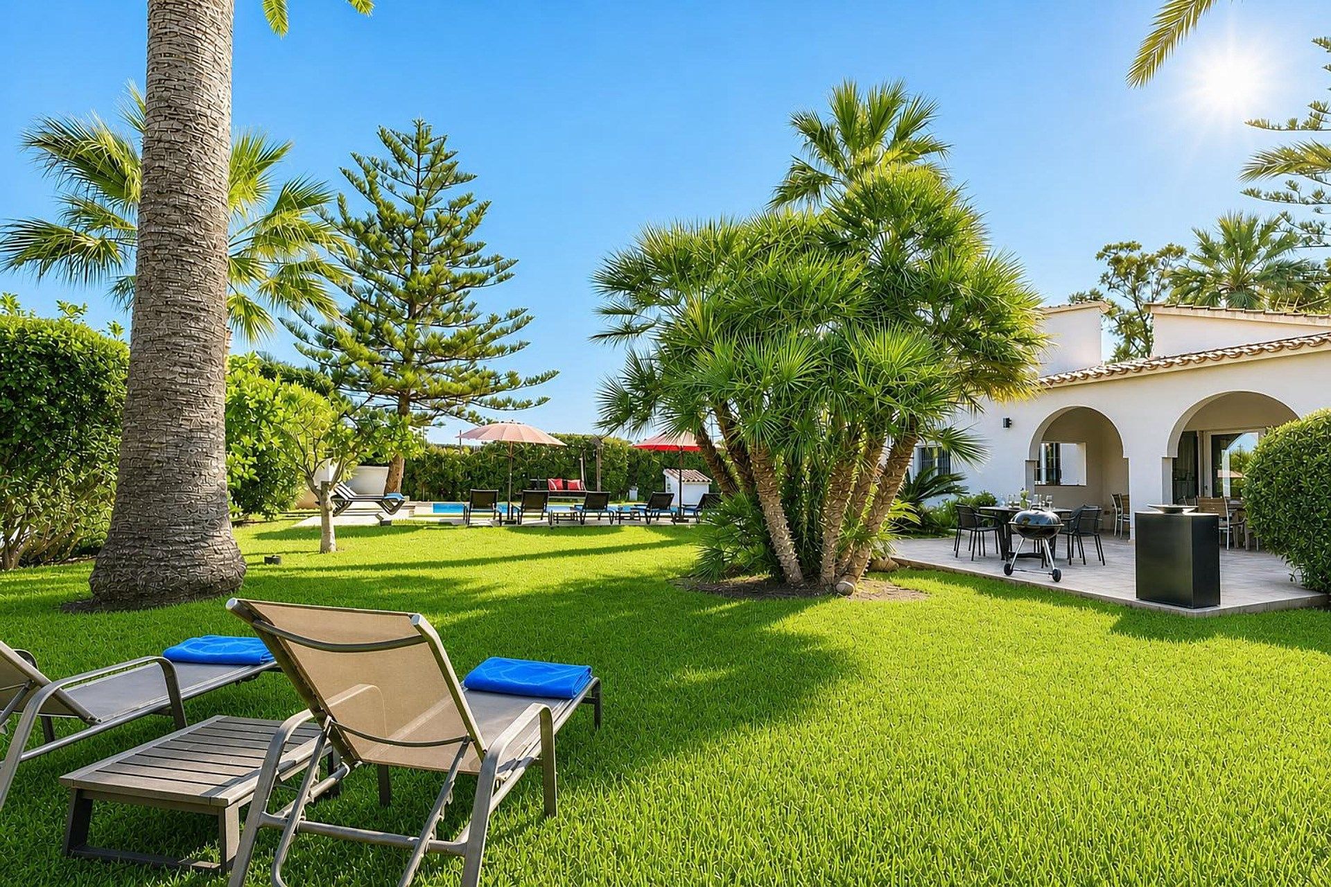 A well-maintained outdoor area with a pool, lounge chairs, and a building with arches.