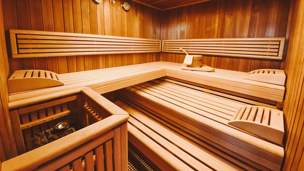 A sauna with wooden benches and a bench with a towel. - Private spa with sauna and whirlpool in an idyllic setting | 10 min from Rothenburg o.d.T. (Schrozberg)