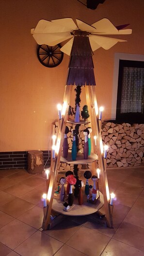 Un suport de fusta decoratiu amb diverses prateleires, cadascuna amb diferents objectes com vasses i figurines, il·luminat per petites llums.