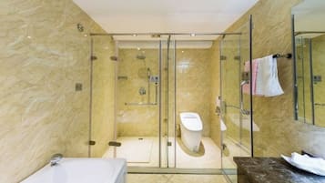 A modern bathroom with a glass-enclosed shower, a white toilet, and a bathtub.