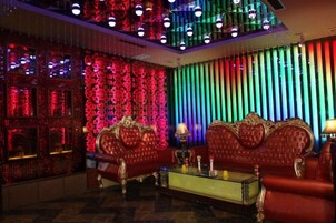 Una habitación con un sofá rojo, una mesa de centro de cristal y una pared con diseño.