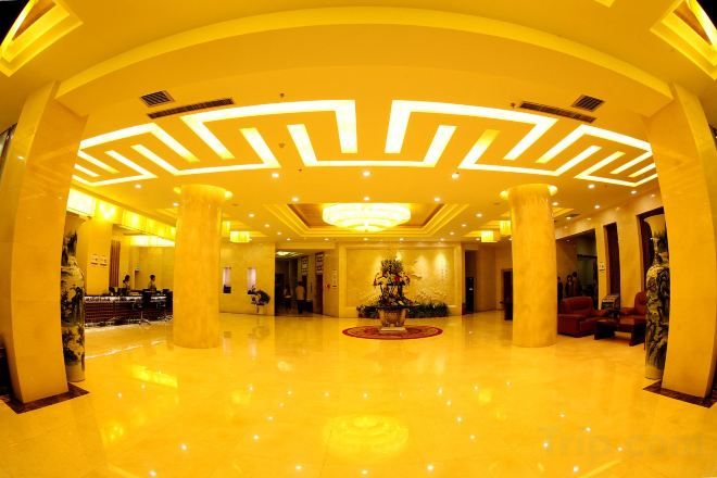 A spacious lobby with a central fountain, large columns, and a modern ceiling design.